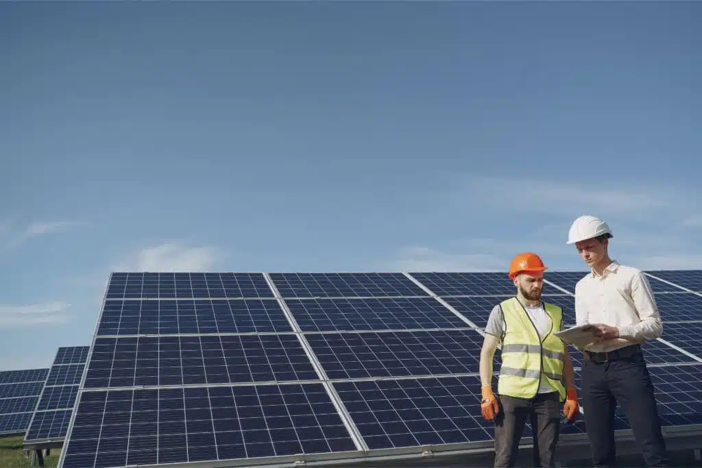 Zwei Planer stehen vor einer PV-Anlage und besprechen Gewerbespeicher